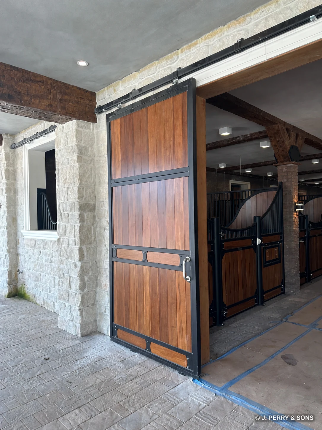 Stone masonry surrounding a wood-and-metal stable door at the Southwest Ranches equestrian project